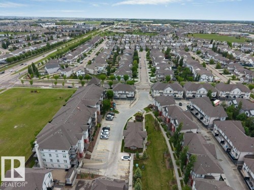 Expansive residential development featuring rows of detached and multi-family homes, mature landscaping, and dedicated green spaces - 401 667 Watt Boulevard, Edmonton, AB 