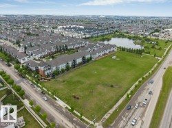 Expansive green space bordered by a multi-lane roadway and residential development - 