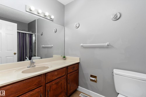 Bathroom vanity featuring a light-colored countertop with an integrated sink and chrome faucet - 14707 33 Street, Edmonton, AB 