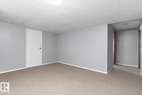 Carpeted room with light gray walls, white baseboards, and a white ceiling - 14707 33 Street, Edmonton, AB 