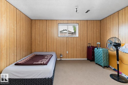 Room featuring wood paneling, a recessed window, and carpet flooring - 14707 33 Street, Edmonton, AB 