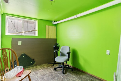 Room featuring vibrant green walls, a window with wood-paneled exterior, and a tiled floor - 14707 33 Street, Edmonton, AB 