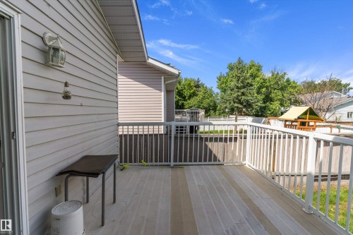 Outdoor deck featuring composite decking, white railing, and exterior siding - 14707 33 Street, Edmonton, AB 