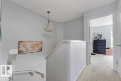 Upper landing featuring light gray walls, white trim, a semi-flush mount ceiling light, and plush light-colored carpeting - 