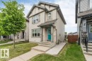 Two-story residential exterior featuring light-colored siding with dark trim accents - 3511 15A Street, Edmonton, AB 