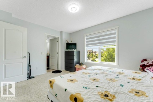 Carpeted room with a large window featuring horizontal blinds - 3511 15A Street, Edmonton, AB 