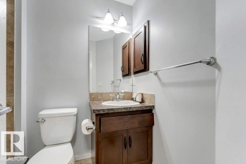 Bathroom featuring a wood-finish vanity with an integrated sink and a speckled countertop - 3511 15A Street, Edmonton, AB 