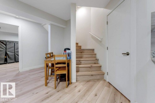Light wood-finish flooring provides a cohesive aesthetic throughout the space - 3511 15A Street, Edmonton, AB 