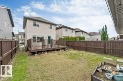 Expansive backyard featuring a large wood deck with railings, a turquoise exterior door, and full perimeter wood fencing - 