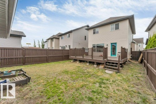 Rear exterior featuring a spacious wooden deck with railings and steps - 3511 15A Street, Edmonton, AB 
