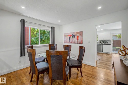 Dining area featuring wood-finish flooring, recessed lighting, and a large window - 3718 103B Street Nw, Edmonton, AB - Indoor Photo Showing Dining Room