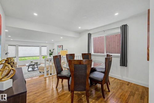 Dining area featuring wood-finish flooring, recessed lighting, and a window with dark drapery - 3718 103B Street Nw, Edmonton, AB - Indoor Photo Showing Dining Room