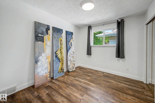Room featuring wood-finish flooring, white walls, and a window with a white frame - 3718 103B Street Nw, Edmonton, AB - Indoor Photo Showing Other Room