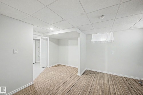 Finished room with wood-finish flooring, white baseboards, and a dropped ceiling with recessed lighting - 3718 103B Street Nw, Edmonton, AB - Indoor Photo Showing Other Room