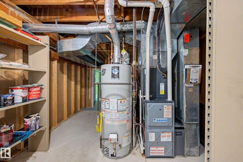 Utility area featuring a water heater, furnace, and exposed overhead ductwork - 3718 103B Street Nw, Edmonton, AB - Indoor Photo Showing Basement