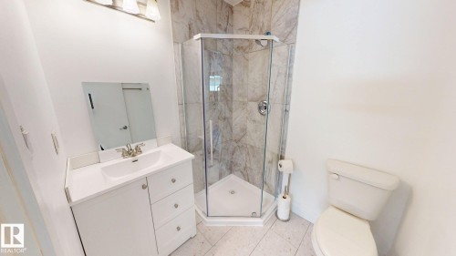 Corner glass-enclosed shower with stone-patterned tile surround - 3718 103B Street, Edmonton, AB 