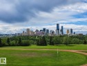 Expansive green space featuring a track, bordered by mature trees and a distant cityscape - 10415 84 Street, Edmonton, AB 
