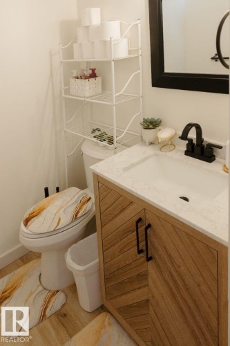 Bathroom vanity with wood-finish cabinetry featuring a herringbone pattern and matte black hardware - 10503A 109 Street, Westlock, AB - Indoor Photo Showing Bathroom