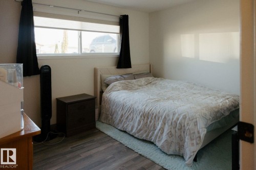 Room featuring wood-finish flooring, a double window with blinds, and white walls - 10503A 109 Street, Westlock, AB - Indoor Photo Showing Bedroom