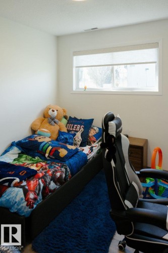 Bright interior space featuring a window with roller blinds, a built-in ceiling light, and light-colored walls - 10503A 109 Street, Westlock, AB - Indoor Photo Showing Bedroom