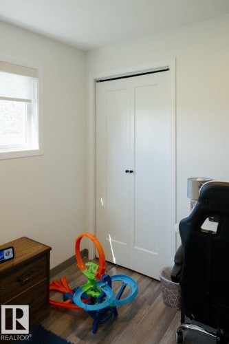 Room featuring wood-finish flooring, light-colored walls, and a window with a roller shade - 10503A 109 Street, Westlock, AB - Indoor Photo Showing Other Room