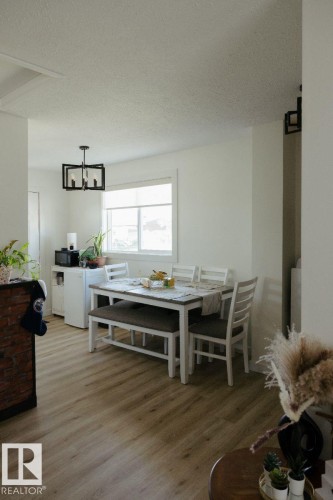Dining area with wood-finish flooring and a contemporary chandelier - 10503A 109 Street, Westlock, AB - Indoor