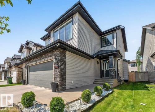 Contemporary exterior featuring horizontal siding and stone veneer accents - 1944 68 Street, Edmonton, AB 