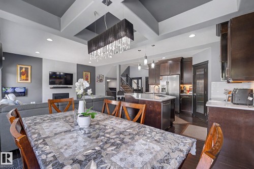 Dining area with tray ceiling and a chandelier featuring crystal accents - 1944 68 Street, Edmonton, AB 