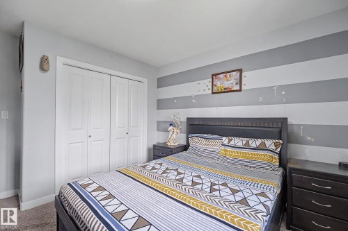 Light gray walls with a striped accent wall - 1944 68 Street, Edmonton, AB 