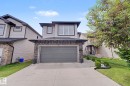 Two-story residential exterior featuring light-colored siding and dark trim accents - 1944 68 Street, Edmonton, AB 