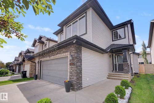 Modern two-story home featuring light-colored siding and dark stone veneer accents - 1944 68 Street, Edmonton, AB 