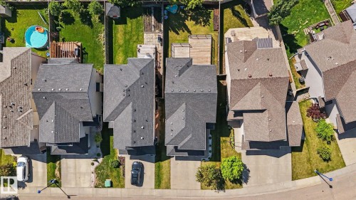 Aerial perspective showcasing multiple residential properties with pitched roofs, individual driveways, and landscaped front yards - 1944 68 Street, Edmonton, AB 