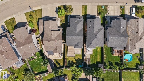 Contemporary residential property featuring a gray shingle roof, paved driveway, and manicured front lawn - 1944 68 Street, Edmonton, AB 