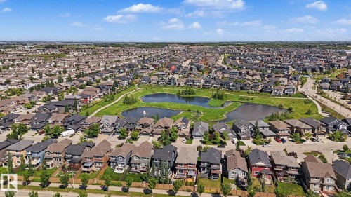 Expansive neighborhood featuring a central pond with a fountain, surrounded by green spaces and walking paths - 1944 68 Street, Edmonton, AB 