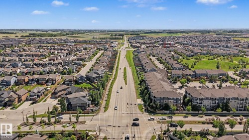Aerial perspective showcasing a residential community with single-family homes and multi-story apartment buildings - 1944 68 Street, Edmonton, AB 