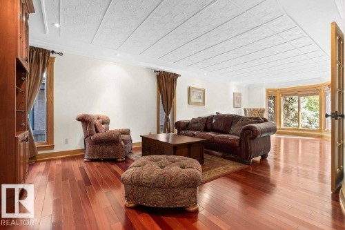 Living area with custom built wall unit, oak trim, cherry flooring and recessed lighting. - 738 Wheeler Road, Edmonton, AB 