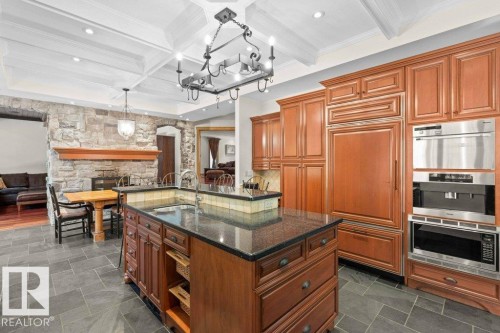 Kitchen with granite countertops, custom tile backsplash, Miele, Subzero and KitchenAid appliances featuring trash compactor, dual wall ovens plus garburator. - 738 Wheeler Road, Edmonton, AB 
