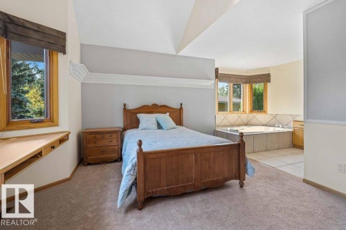 Bedroom with light carpet, light tile patterned flooring, and vaulted ceiling - 738 Wheeler Road, Edmonton, AB 