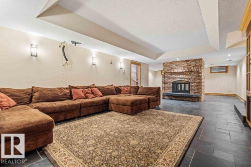 Home theatre w/power 120” screen, featuring two sided wood burning fireplace, heated slate flooring and custom millwork. - 738 Wheeler Road, Edmonton, AB 
