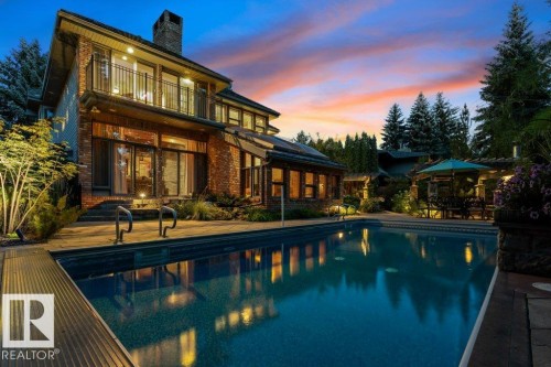Rear view of house with pool, patio, balcony and reclaimed brick exterior. - 738 Wheeler Road, Edmonton, AB 