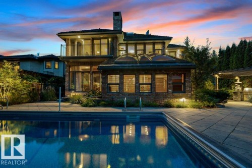 Rear view of house with pool, patio, balcony and reclaimed brick exterior. - 738 Wheeler Road, Edmonton, AB 