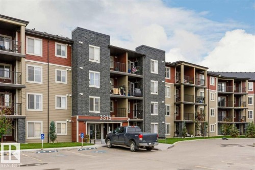 Multi-story building featuring stacked stone and horizontal siding - 328 3315 James Mowatt Trail, Edmonton, AB 