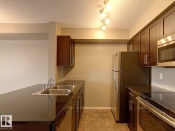 Modern kitchen featuring dark wood-finish cabinetry and dark countertops - 