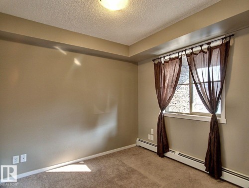 Window with dark sheer curtains - 328 3315 James Mowatt Trail, Edmonton, AB 