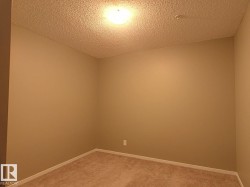 Room with tan wall paint and textured ceiling, featuring recessed lighting and carpet flooring - 