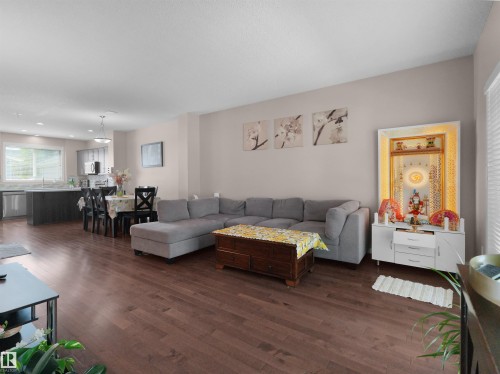 Open-concept living area featuring rich wood-finish flooring - 7827 22 Avenue, Edmonton, AB 