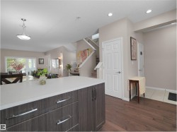 Kitchen island with a light-toned countertop, wood-finish cabinetry, and stainless steel hardware - 