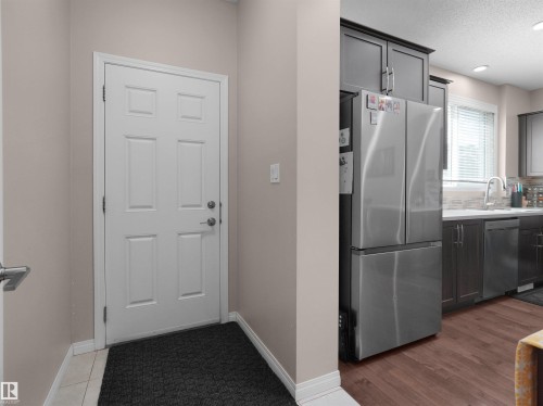 Panel-style interior door framed by neutral walls and white trim - 7827 22 Avenue, Edmonton, AB 