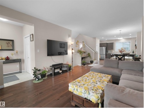Open-concept living space featuring wood-finish flooring, neutral wall tones, and recessed lighting - 7827 22 Avenue, Edmonton, AB 