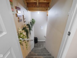 Carpeted staircase with white handrail and recessed lighting - 